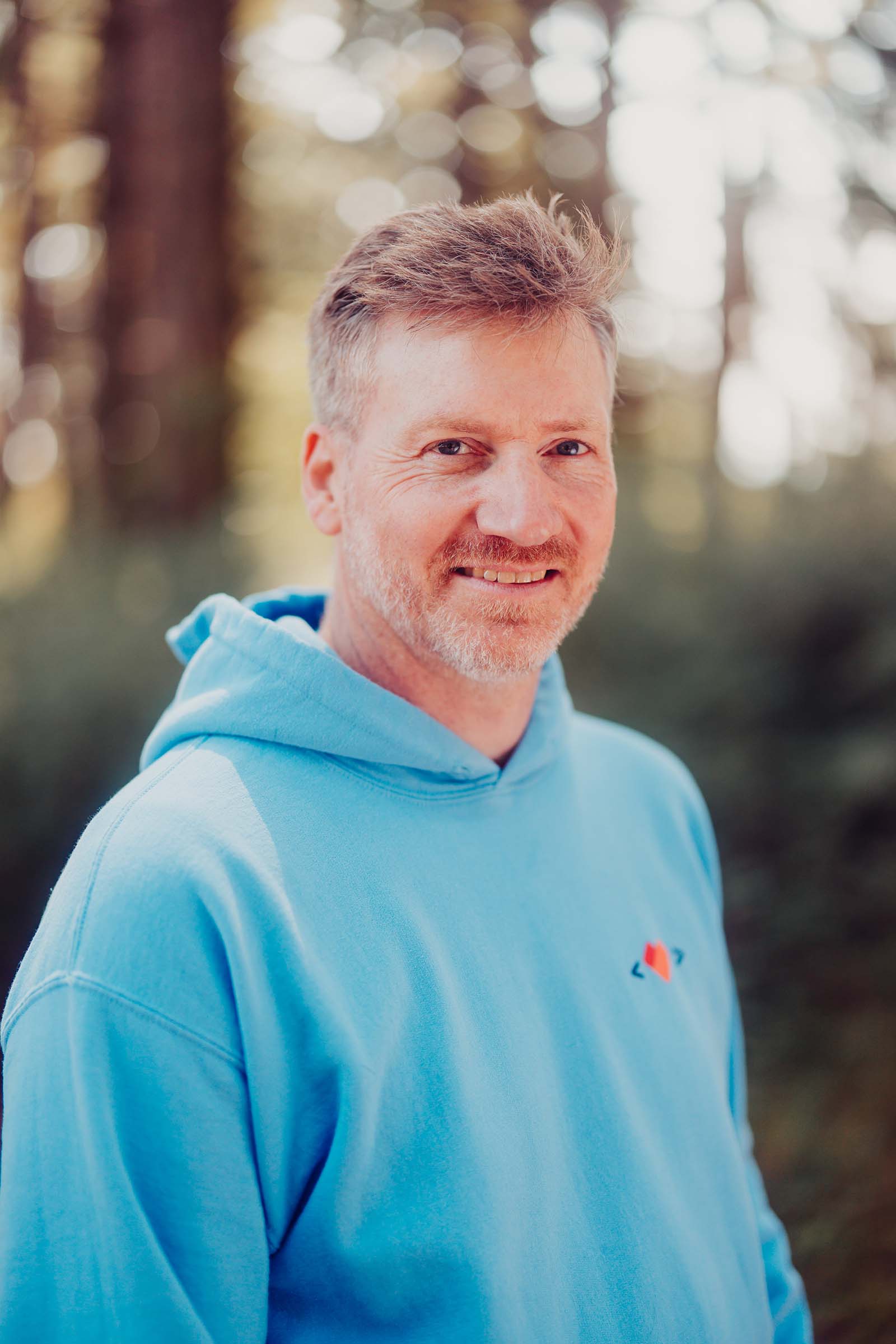 Headshot in the forest of Tom Alexander, graphic designer at Websites Made With Love