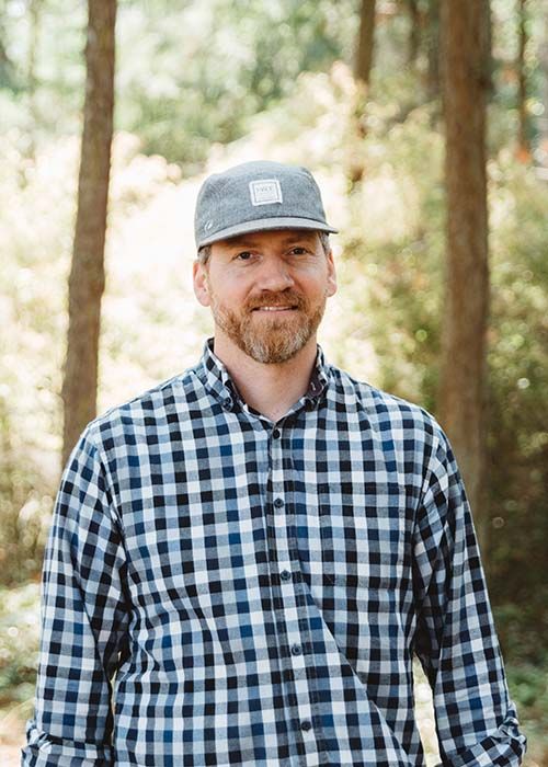 Headshot in the forest of Tom Alexander, graphic designer at Websites Made With Love